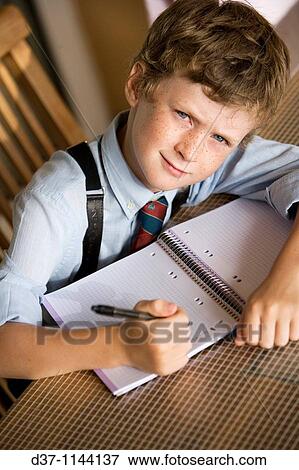 Caucasian boy writing on a notebook View Large Photo Image Stock Photo - Caucasian boy writing on a notebook. Fotosearch