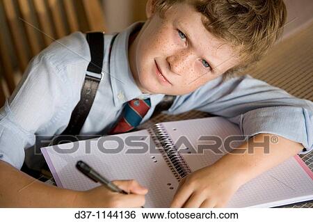 Caucasian boy writing on a notebook View Large Photo Image Stock Photograph - Caucasian boy writing on a notebook. Fotosearch