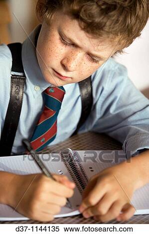 Caucasian boy writing on a notebook concentrated View Large Photo Image Stock Photography - Caucasian boy writing on a notebook concentrated. Fotosearch
