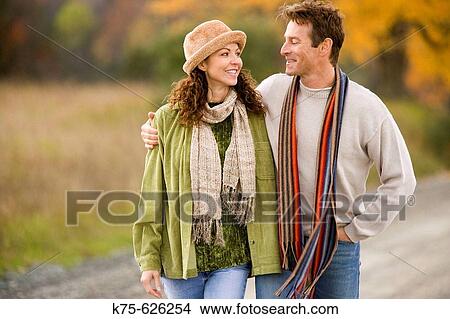Caucasian couple, age 30's to 40? s, country road, autumn, hugging View Large Photo Image Picture - Caucasian couple, age 30's to 40? s, country road, autumn, hugging. Fotosearch