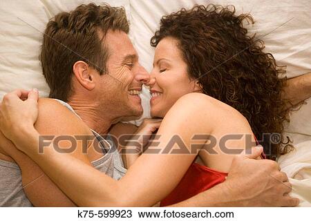 Stock Image - caucasian couple, age 30's to 40? s, bed, hugging. Fotosearch