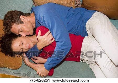 Caucasian couple, age 30's to 40? s, lying down, hugging, couch View Large Photo Image Stock Image - Caucasian couple, age 30's to 40? s, lying down, hugging, couch. Fotosearch