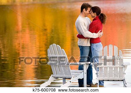 Caucasian couple, age 30's to 40? s, adirondack chairs, lake, dock, autumn, hugging, embracing, reflection View Large Photo Image Stock Photo - Caucasian couple, age 30's to 40? s, adirondack chairs, lake, dock, autumn, hugging, embracing, reflection. Fotosearch