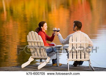 Caucasian couple, age 30's to 40? s, wine, adirondack chairs, dock, lake, autumn, reflection View Large Photo Image Stock Photography - Caucasian couple, age 30's to 40? s, wine, adirondack chairs, dock, lake, autumn, reflection. Fotosearch