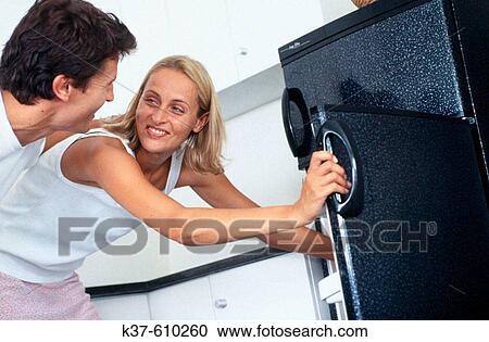 Caucasian couple looking in fridge together View Large Photo Image Stock Image - Caucasian couple looking in fridge together. Fotosearch