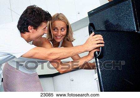 Caucasian couple looking in fridge together View Large Photo Image Stock Photography - Caucasian couple looking in fridge together. Fotosearch
