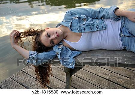 Caucasian female brown haired model eighteen year old lying on bench on wooden pier View Large Photo Image Stock Image - Caucasian female brown haired model eighteen year old lying on bench on wooden pier. Fotosearch