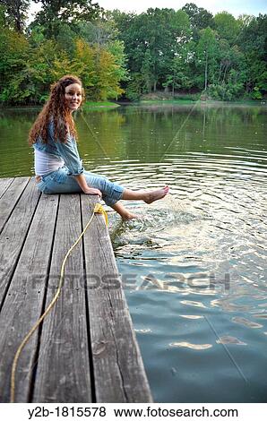 Caucasian female brown haired model eighteen year old sitting on wooden pier View Large Photo Image Stock Photo - Caucasian female brown haired model eighteen year old sitting on wooden pier. Fotosearch