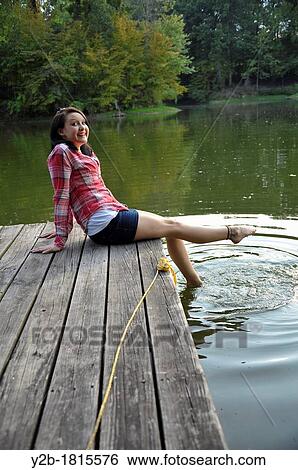 Caucasian female model fifteen year old brunette sitting on wooden dock View Large Photo Image Stock Photograph - Caucasian female model fifteen year old brunette sitting on wooden dock. Fotosearch