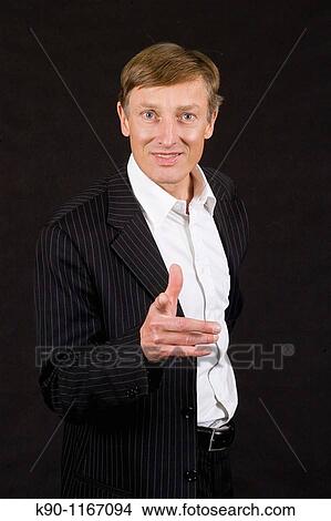 Picture - Caucasian man with friendly pose, pointing with his finger at the camera, studio shot. Fotosearch