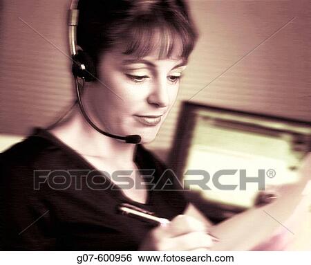 Stock Photograph - Caucasian or Latin professional woman sitting in work space cubicle. Fotosearch