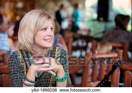 Caucasian woman in her 40s sitting at a table in a rustic outdoor restaurant View Large Photo Image Stock Photograph - Caucasian woman in her 40s sitting at a table in a rustic outdoor restaurant. Fotosearch