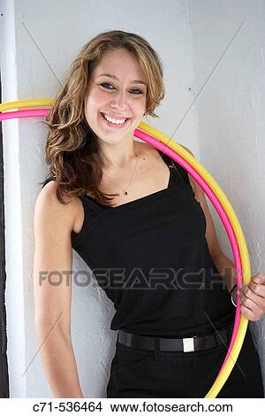 Picture - Caucasian woman looking into the camera with hula hoops around neck. Fotosearch