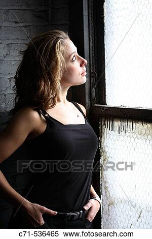Stock Photography - Caucasian woman looking out the window. Fotosearch