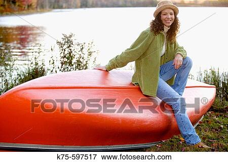 Stock Photo - Caucasian woman smiling by canoe. Fotosearch