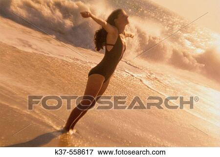 Caucasian woman stretching on beach with arms outstretched. View Large Photo Image Stock Photo - Caucasian woman stretching on beach with arms outstretched.. Fotosearch