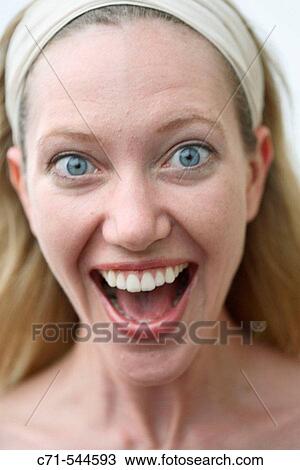 Stock Image - Caucasian woman surprised with mouth open looking into camera. Fotosearch