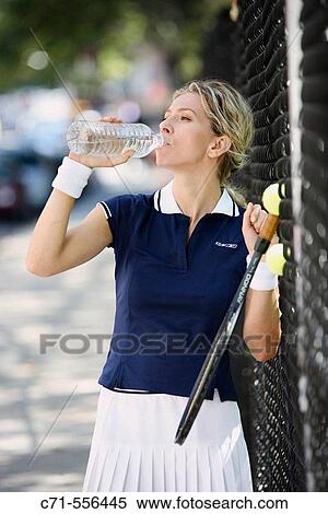 Caucasian woman tennis player drinking water from a water bottle View Large Photo Image Stock Photography - Caucasian woman tennis player drinking water from a water bottle. Fotosearch