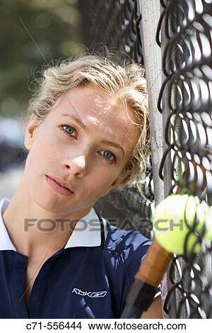 Caucasian woman tennis player leaning on fence looking into camera View Large Photo Image Picture - Caucasian woman tennis player leaning on fence looking into camera. Fotosearch