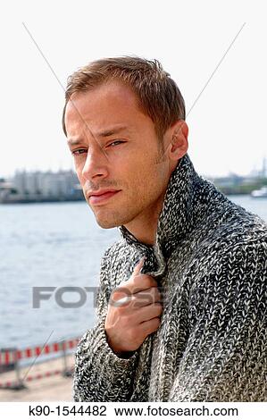 Caucasian young man, head and shoulders, looking critically at the camera and holding one hand at his chest, waterr in the background, Hamburg, Germany, Europe View Large Photo Image Stock Image - Caucasian young man, head and shoulders, looking critically at the camera and holding one hand at his chest, waterr in the background, Hamburg, Germany, Europe. Fotosearch