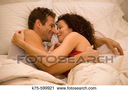 Stock Image - Caucasians, couple, bed, hugging, embrace, romantic, age 30's to 40? s. Fotosearch