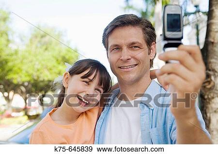 caucasians; dad, age 30 to 40, daughter, age 9, camera phone, smiling, bonding View Large Photo Image Stock Photo - caucasians; dad, age 30 to 40, daughter, age 9, camera phone, smiling, bonding. Fotosearch