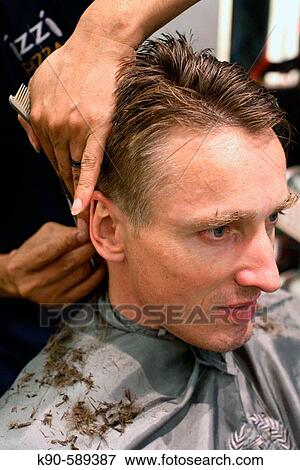 Caucasion man at hairdresser with hairdresser cutting his blond hair View Large Photo Image Stock Photo - Caucasion man at hairdresser with hairdresser cutting his blond hair. Fotosearch