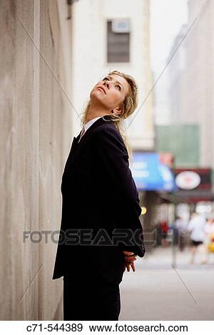 Stock Photo - Caucassian businesswoman looking up to the sky. Fotosearch