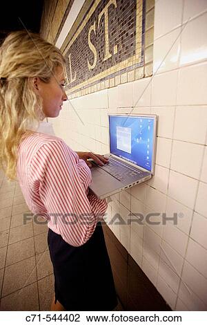 Caucassian businesswoman with laptop push against wall in subway station View Large Photo Image Stock Image - Caucassian businesswoman with laptop push against wall in subway station. Fotosearch