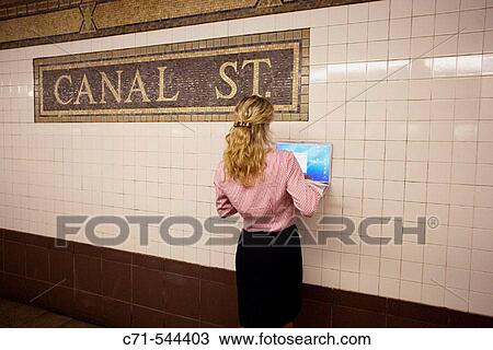 Caucassian businesswoman with laptop pushed against wall in subway station View Large Photo Image Stock Image - Caucassian businesswoman with laptop pushed against wall in subway station. Fotosearch
