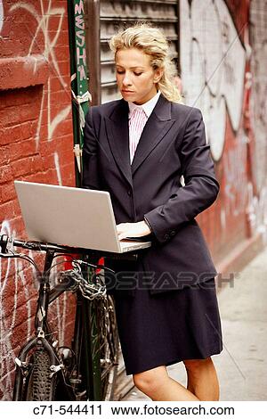 Caucassian businesswoman working on laptop leaning on bicycle against a graffiti wall View Large Photo Image Stock Image - Caucassian businesswoman working on laptop leaning on bicycle against a graffiti wall. Fotosearch
