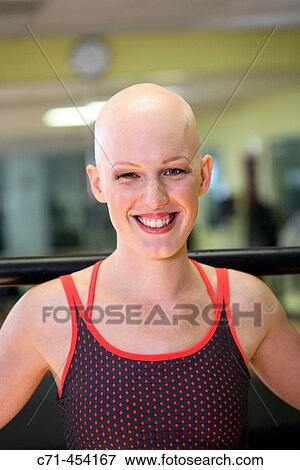 Stock Photo - Caucassian Woman with alopecia areata/cancer survivor working out at the gym. Fotosearch