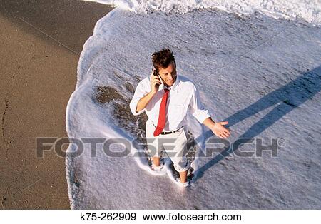 Stock Photo - Cell phone conversation at the beach. Fotosearch