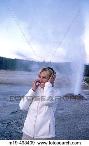 Stock Photo - cell phone conversation during erupting geyser. Fotosearch