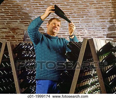 Cellarman checking a Champagne bottle in cellar Champagne France. View Large Photo Image Picture - Cellarman checking a Champagne bottle in cellar Champagne France.. Fotosearch