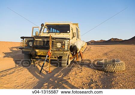 Changing of a flat tyre in the desert, Namibia, Africa View Large Photo Image Stock Photo - Changing of a flat tyre in the desert, Namibia, Africa. Fotosearch