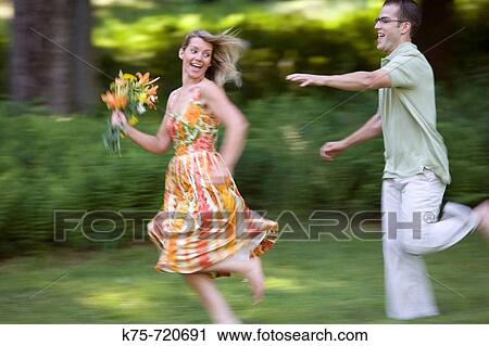Stock Image - Chasing girl with flowers. Fotosearch