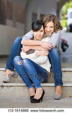 Stock Photo - Cheek to cheek happy young girlfriends. Fotosearch