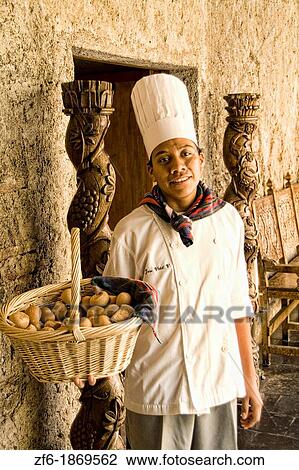 Stock Image - Chef with bread at Hallway of old monastry in the World Renowned Casa Santo Domingo Hotel considered best in Central America in the tourism town of Antigua Guatemala. Fotosearch
