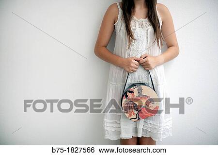 Chica joven esperando apoyada en la pared con bolso en la mano con aspecto romBntico, Young girl waiting against the wall with purse in hand with romantic look, View Large Photo Image Stock Photograph - Chica joven esperando apoyada en la pared con bolso en la mano con aspecto romBntico, Young girl waiting against the wall with purse in hand with romantic look,. Fotosearch