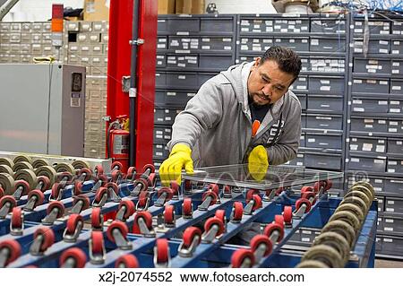 Stock Image - Chicago, Illinois - Members of the New Era Windows Cooperative assemble windows in their plant on Chicago's southwest side.. Fotosearch