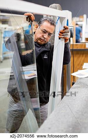 Stock Photograph - Chicago, Illinois - Members of the New Era Windows Cooperative assemble windows in their plant on Chicago's southwest side.. Fotosearch