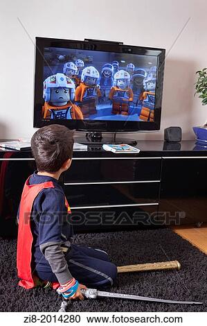 Stock Image - Child alone at home watches Television. Fotosearch