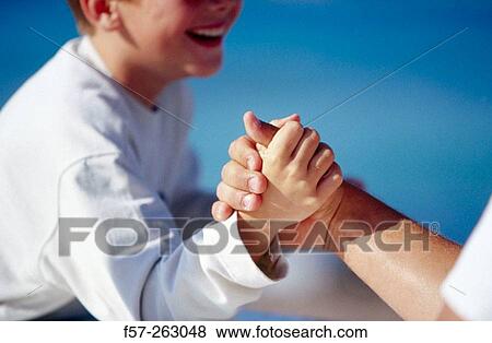 Stock Photo - Child and adult arm wrestling. Fotosearch