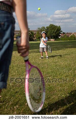 Stock Image - child and parent playing tennis together. Fotosearch
