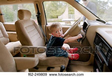 Stock Photo - Child at car's steering wheel. Fotosearch