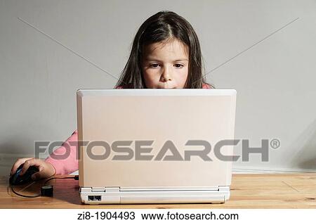Stock Image - Child browsing the internet on a laptop computer. Fotosearch