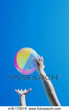 Stock Photo - Child catching a beach ball. Fotosearch