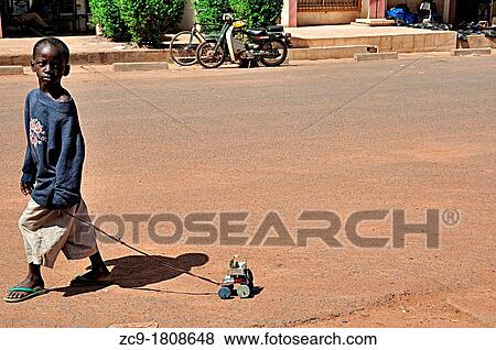 Child dragging his toy car made from recycled materials, Segou, Mali View Large Photo Image Stock Photo - Child dragging his toy car made from recycled materials, Segou, Mali. Fotosearch