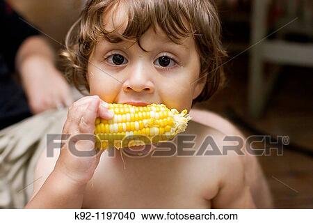 Stock Image - Child eating corn-on-the-cob. Fotosearch